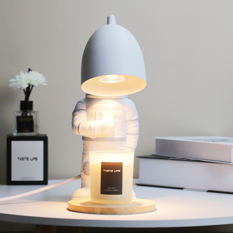 Astronaut Adjustable Heat Candle Warmer Lamp with Timer. Unique space-themed design with adjustable heat for even candle melting. Safe, smoke-free.