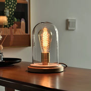 Lightbulb-shaped Transparent Glass Table Lamp. A sleek and modern table lamp in the shape of a lightbulb, perfect for adding an artistic and contemporary flair to your home decor.