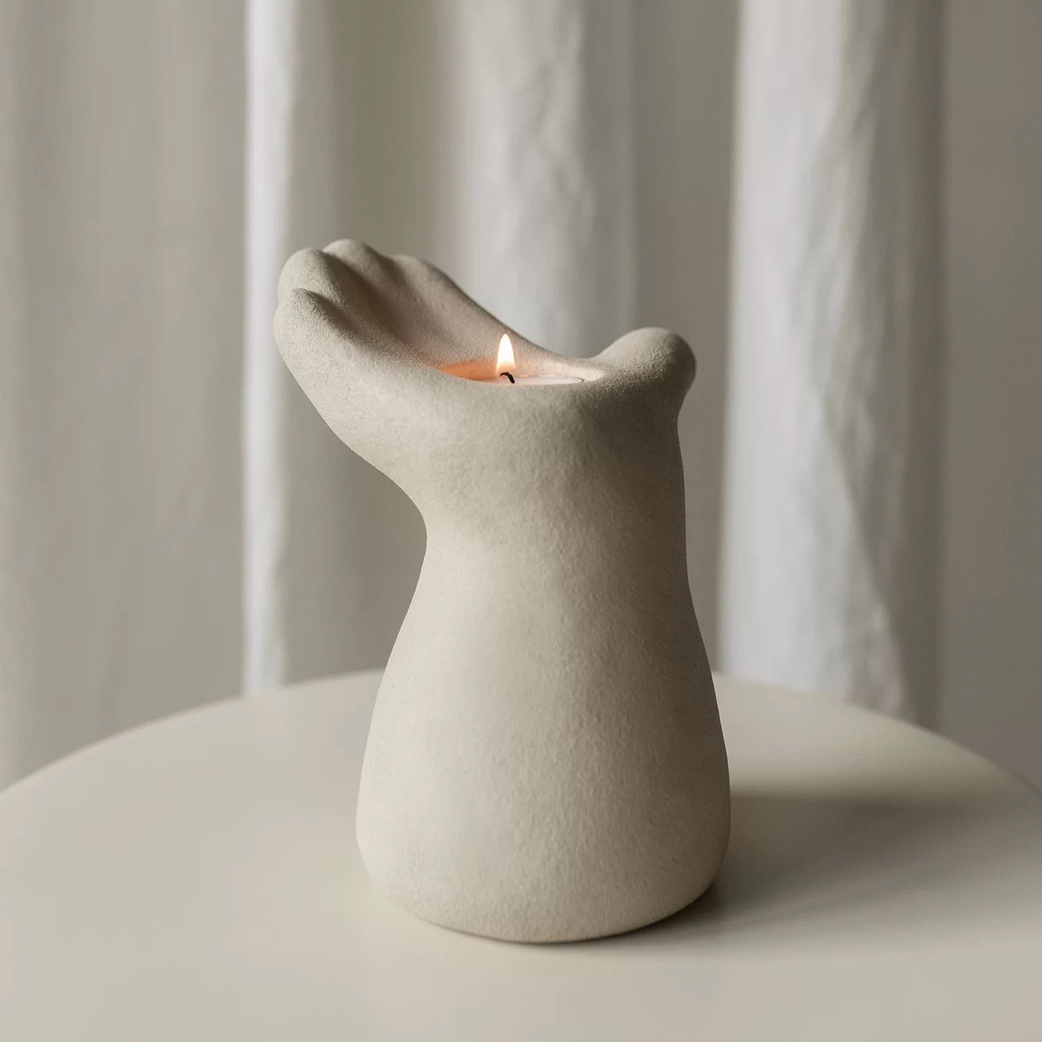 hand-shaped candle holder, designed with an upward-facing palm cradling a candle for a captivating artistic touch