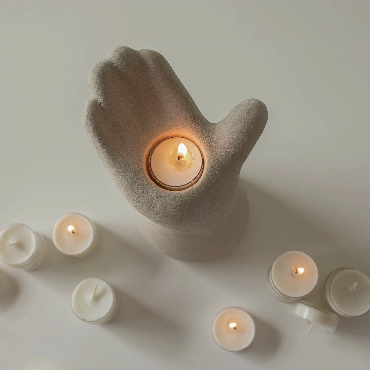 hand-shaped candle holder, designed with an upward-facing palm cradling a candle for a captivating artistic touch