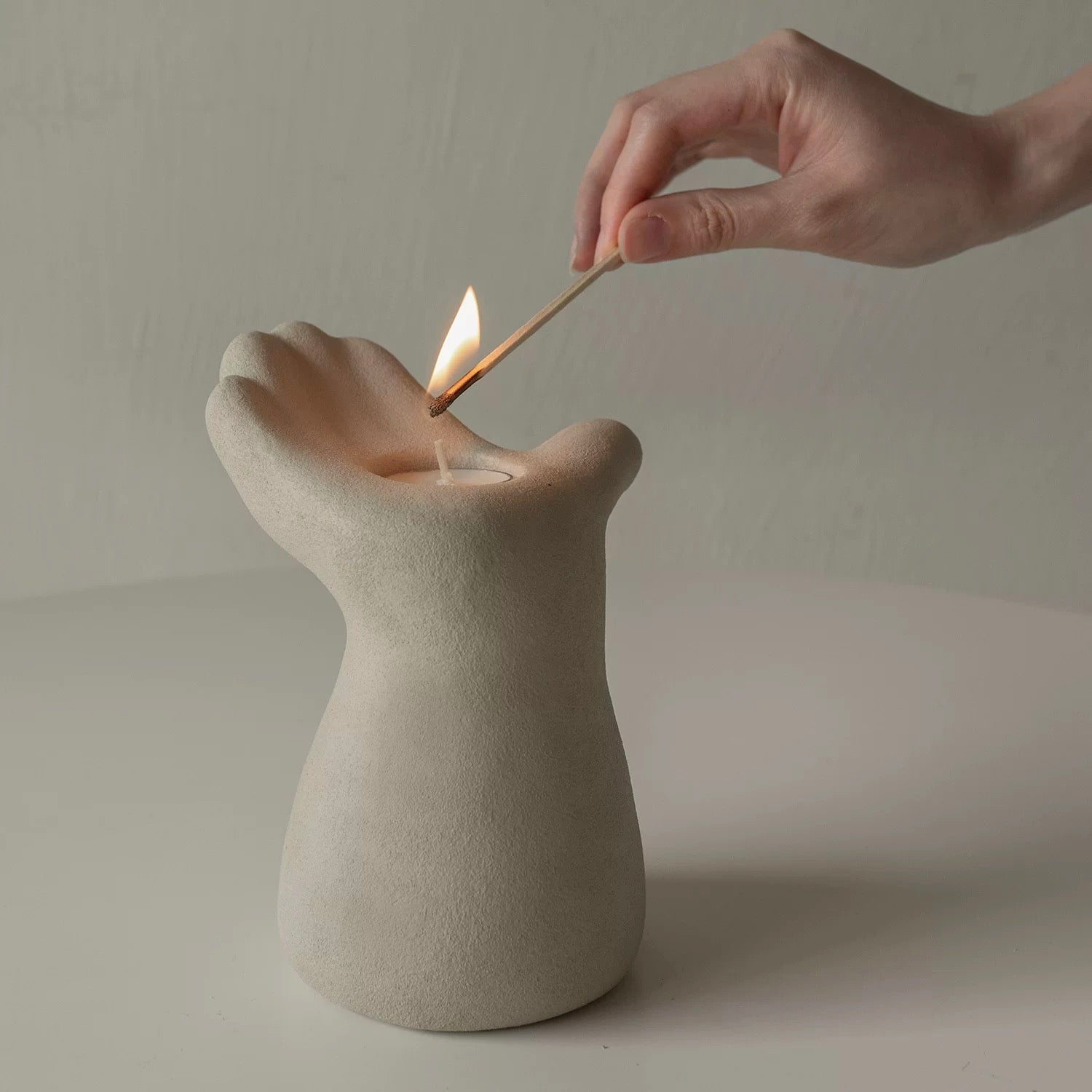 hand-shaped candle holder, designed with an upward-facing palm cradling a candle for a captivating artistic touch